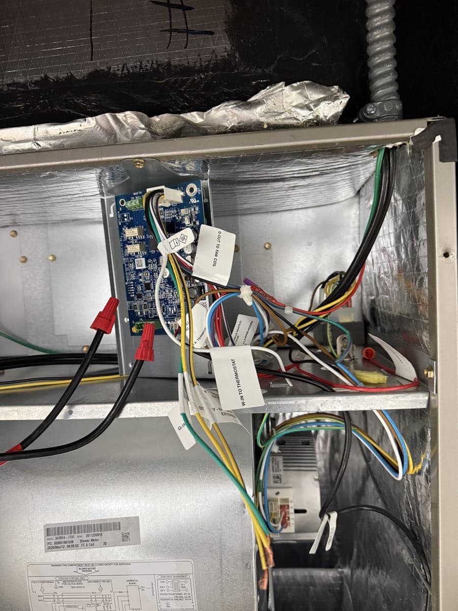 Open indoor unit cabinet showing a control board and wiring